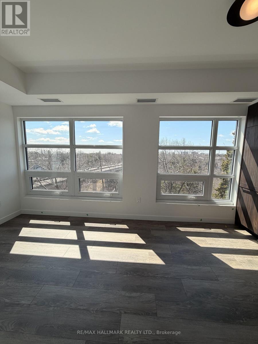 A room with large windows and a view of trees outside.