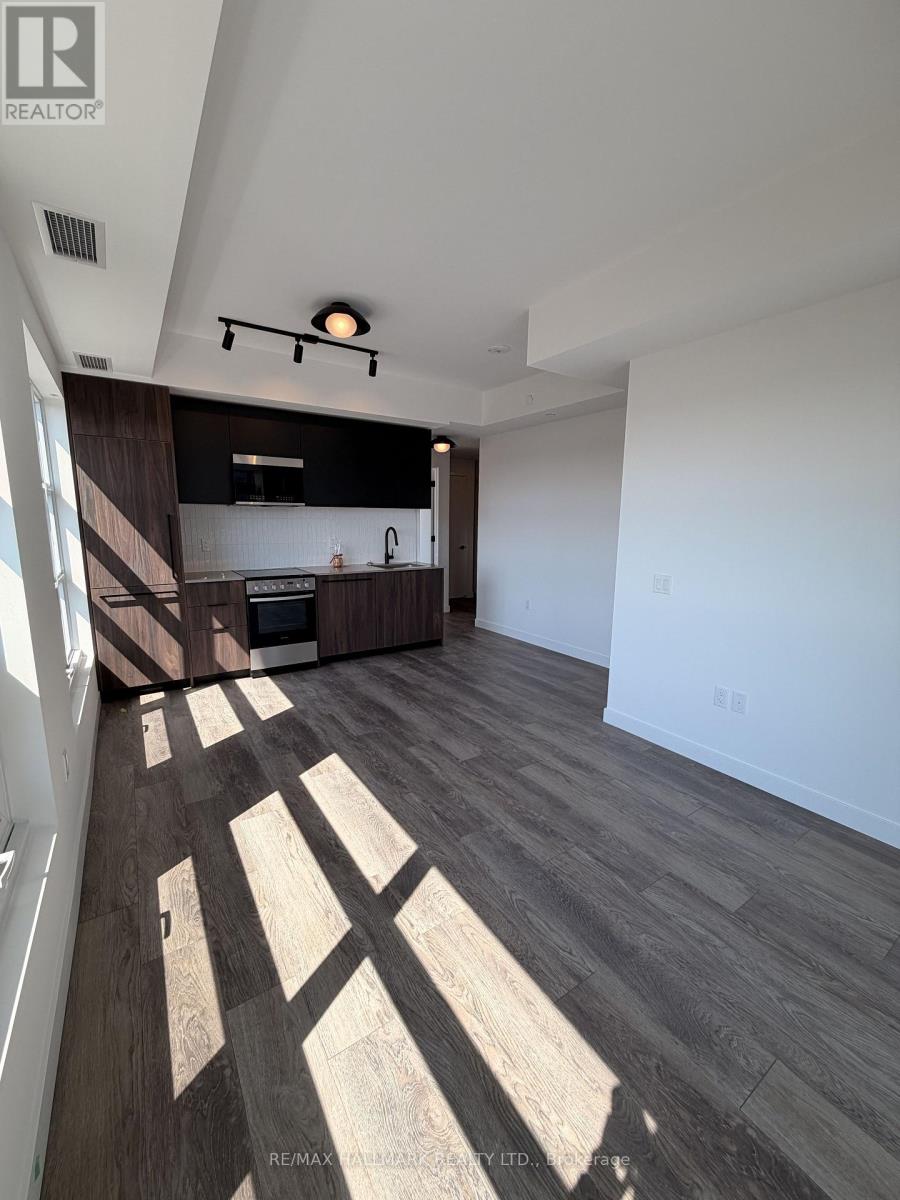 A spacious living room with a kitchen area in the background.