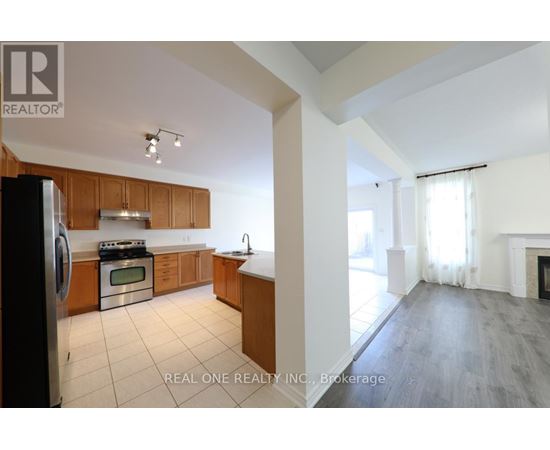 A kitchen with wooden cabinets and a black refrigerator.