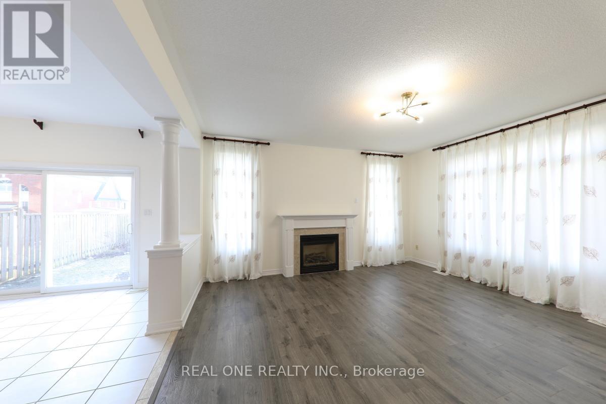 A spacious living room with a fireplace and large windows.
