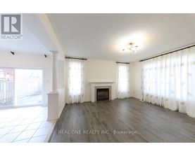 A spacious living room with a fireplace and large windows.