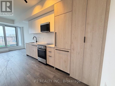 A kitchen with wooden cabinets and a microwave above the stove.