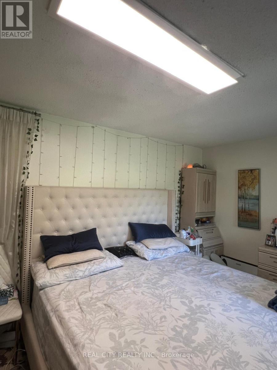 A bedroom with a large bed and a painting on the wall.
