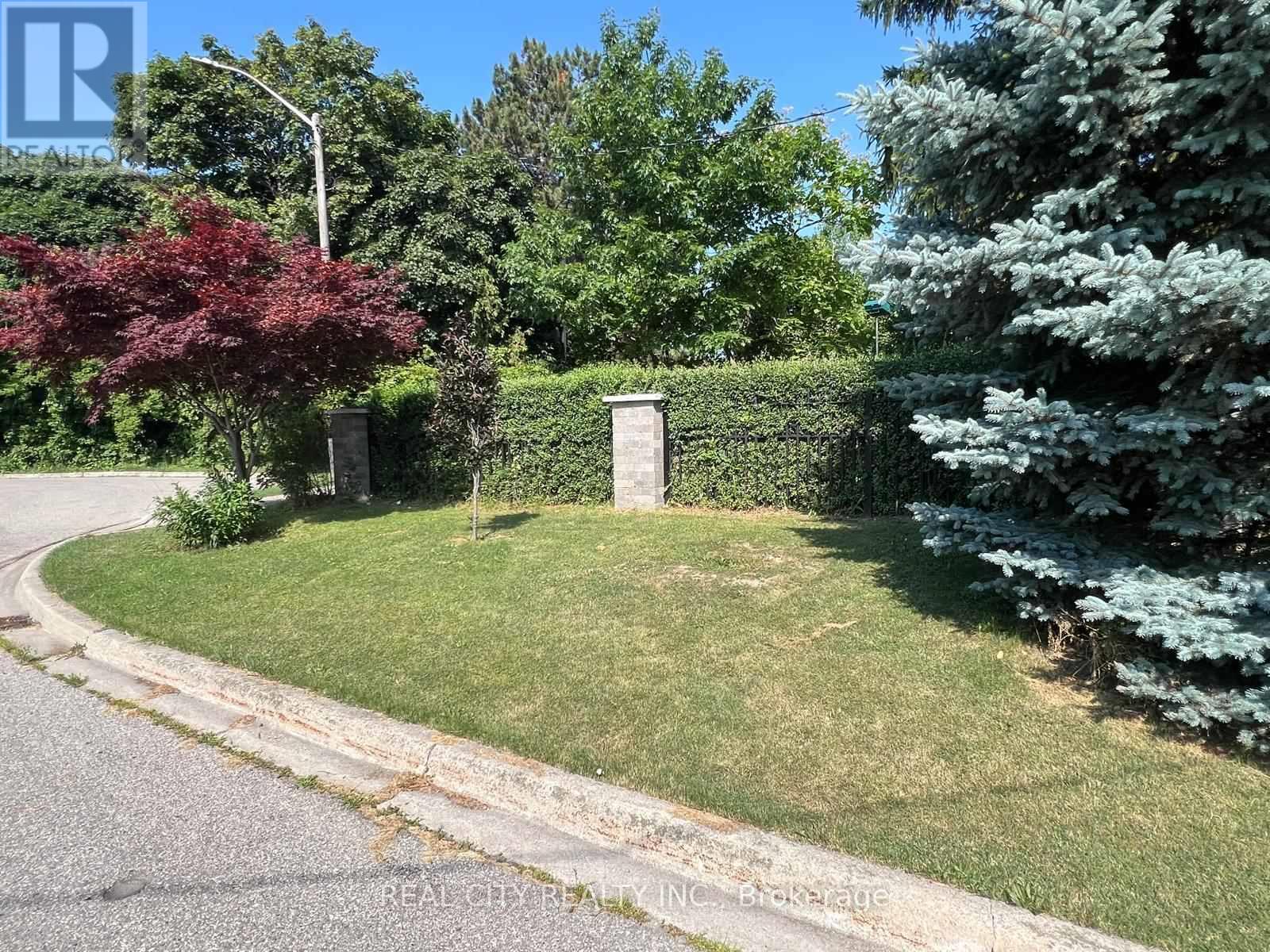 A green lawn with a mailbox and trees in the background.