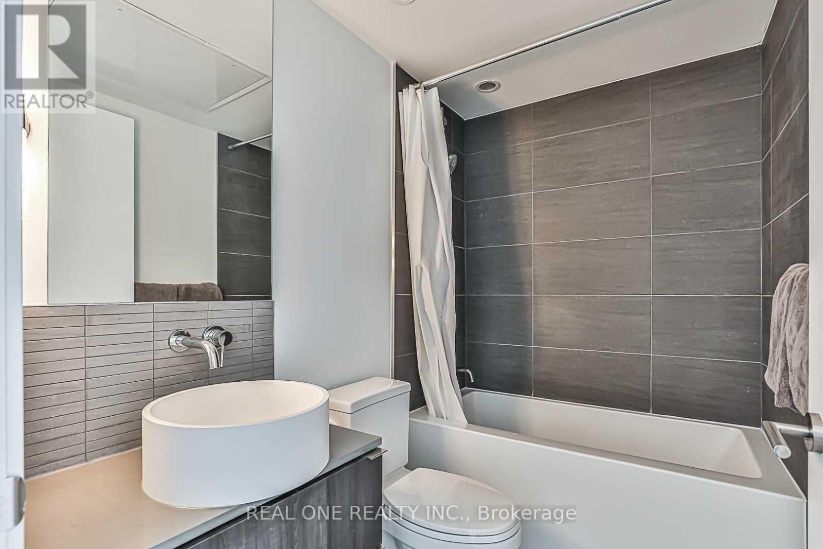 A modern bathroom with a white sink and a bathtub.