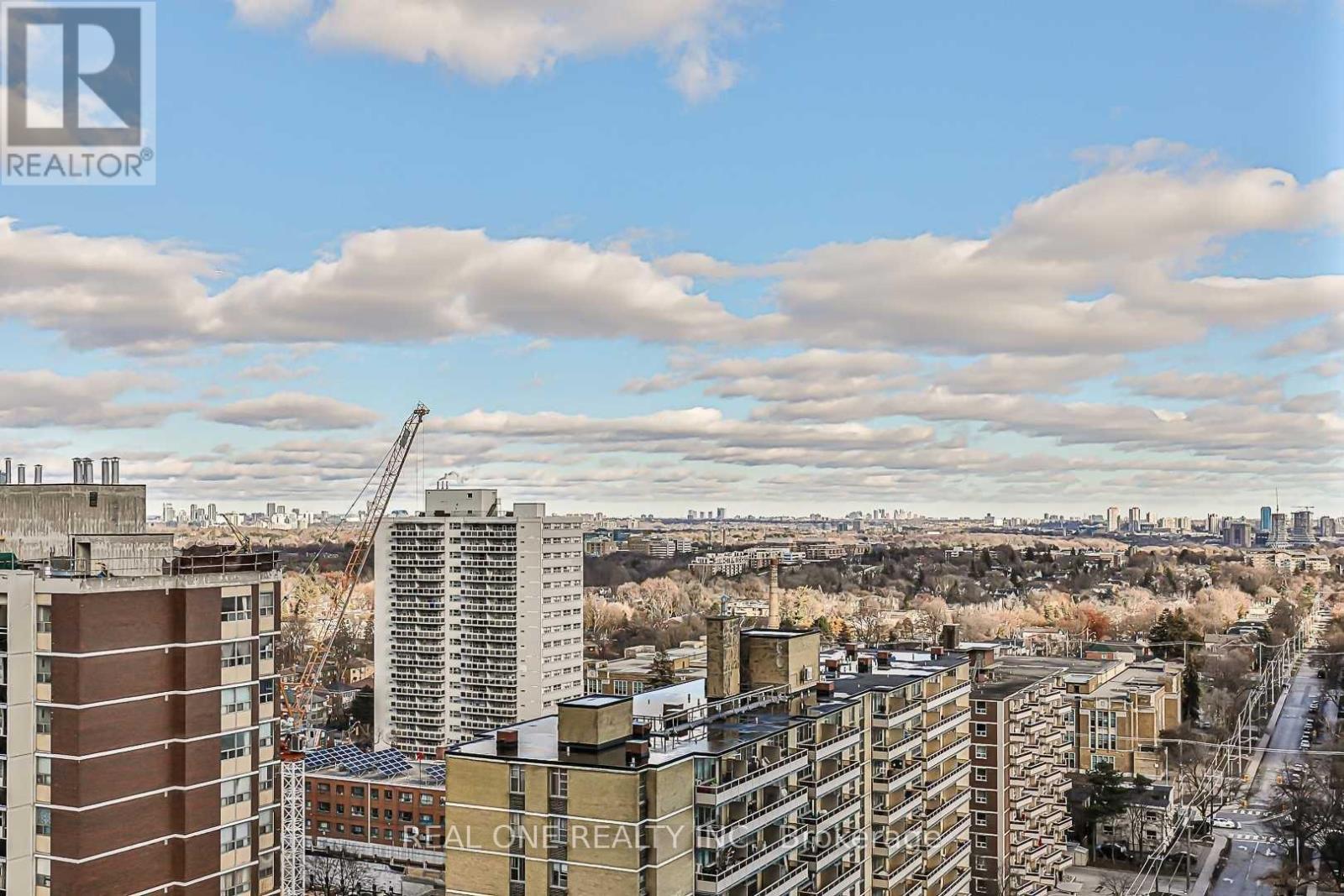 A cityscape with buildings and a crane in the distance.