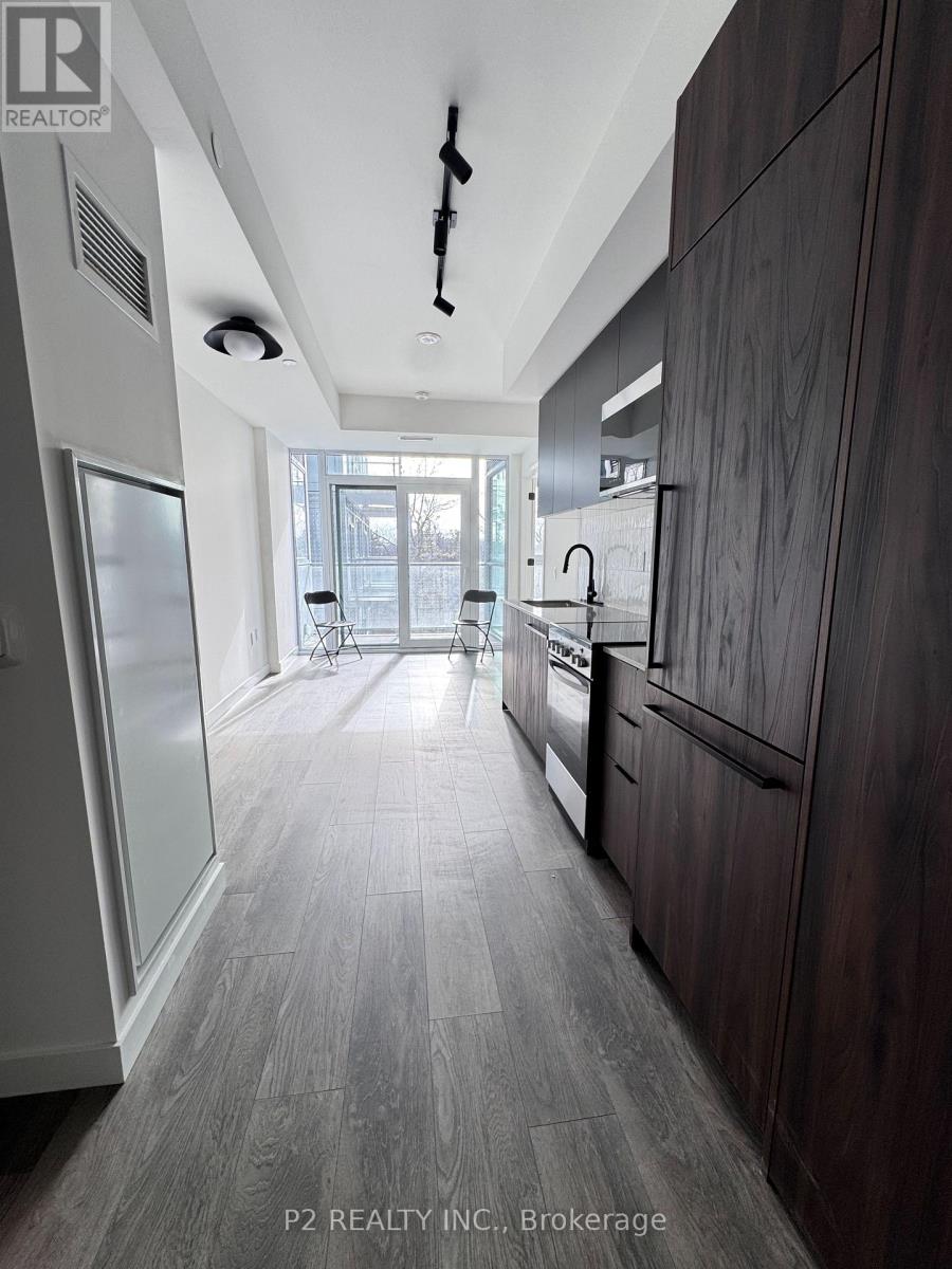 A modern kitchen with dark wood cabinets and a white ceiling.