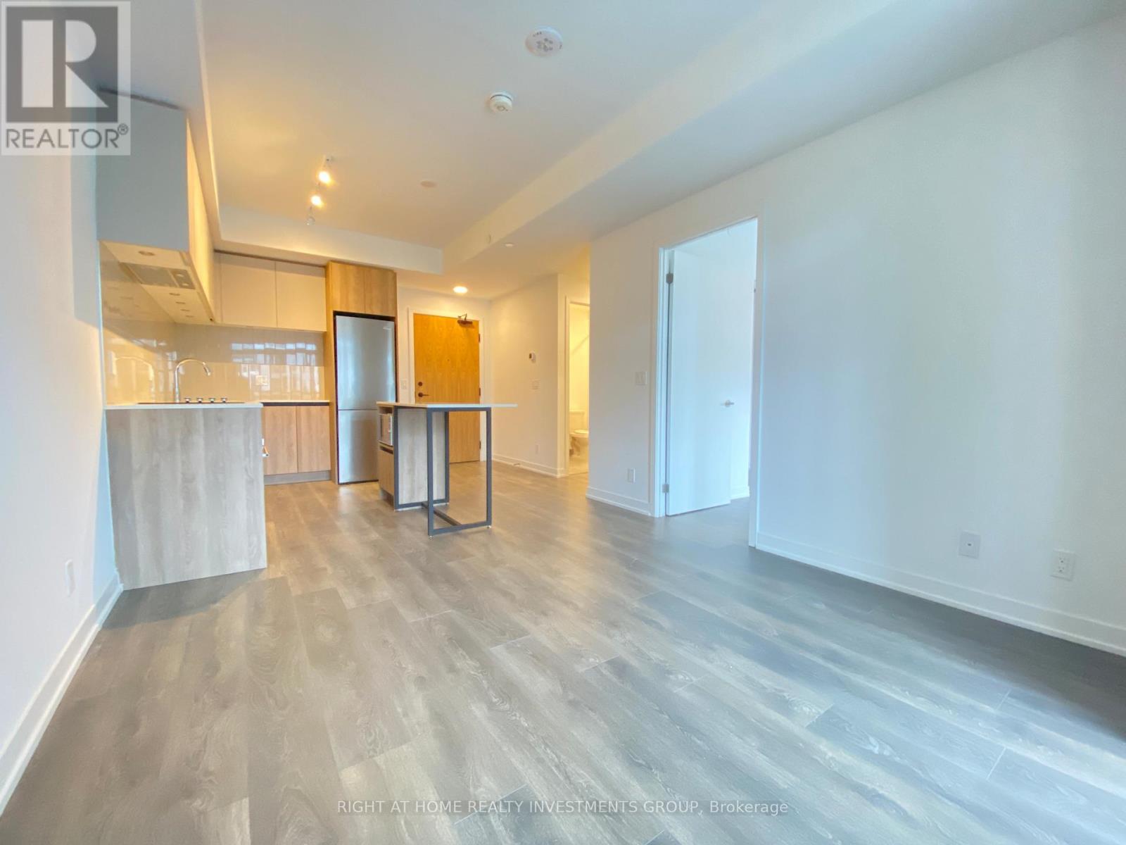 A spacious room with a wooden floor and white walls.