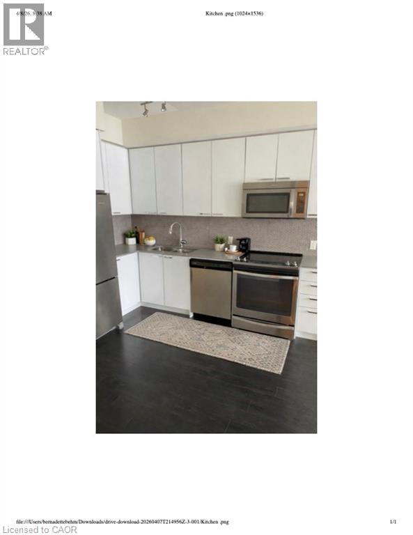 A kitchen with white cabinets and a black countertop.