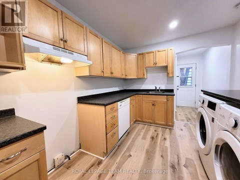 A kitchen with wooden cabinets and a black countertop.