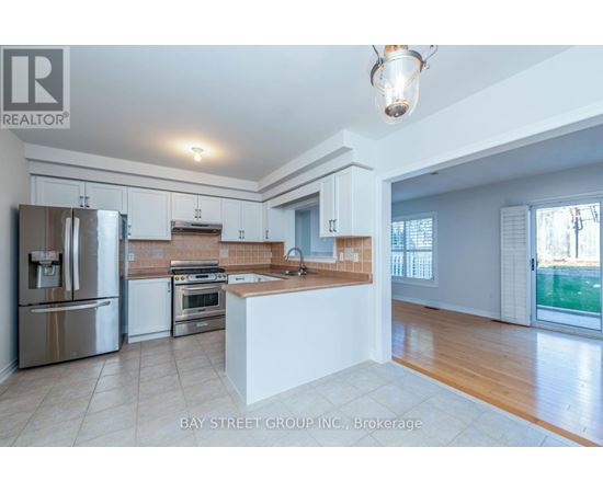 A kitchen with white cabinets and a stainless steel refrigerator.