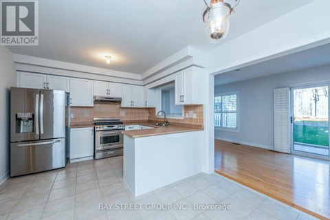 A kitchen with white cabinets and a stainless steel refrigerator.