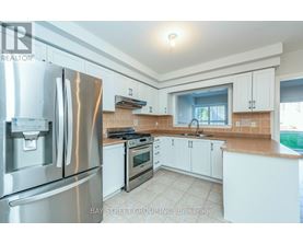 A kitchen with white cabinets and a stainless steel refrigerator.
