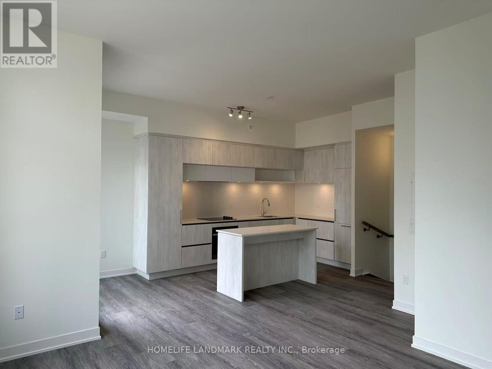 A spacious kitchen with white cabinets and a wooden island.