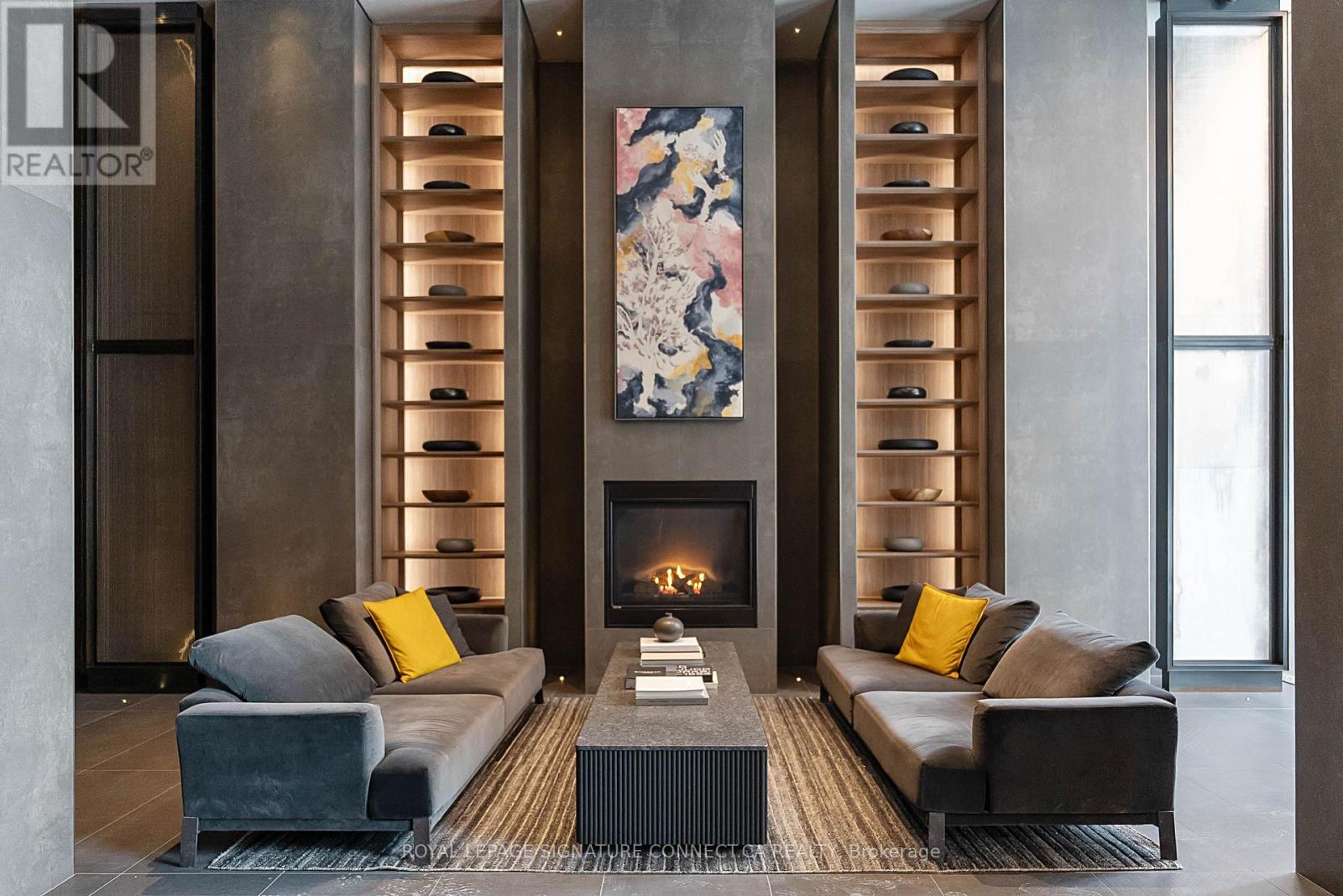 A modern living room with a fireplace and two couches.
