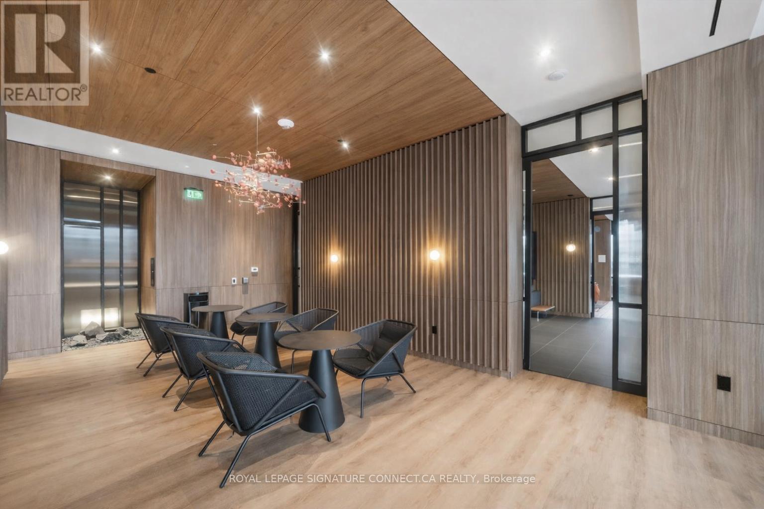 A modern dining room with a wooden floor and a chandelier.
