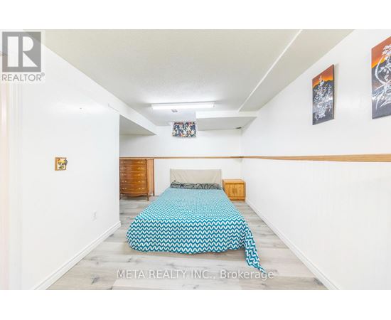 A bedroom with a bed covered in a blue and white patterned bedspread.