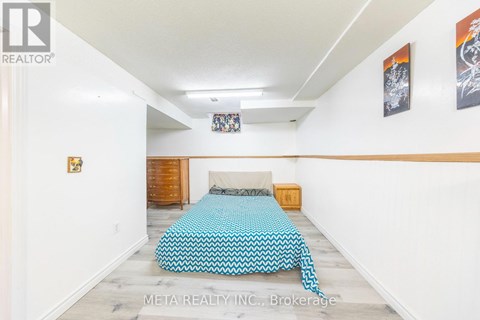 A bedroom with a bed covered in a blue and white patterned bedspread.
