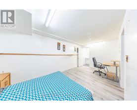 A bedroom with a bed covered in a blue and white patterned bedspread.
