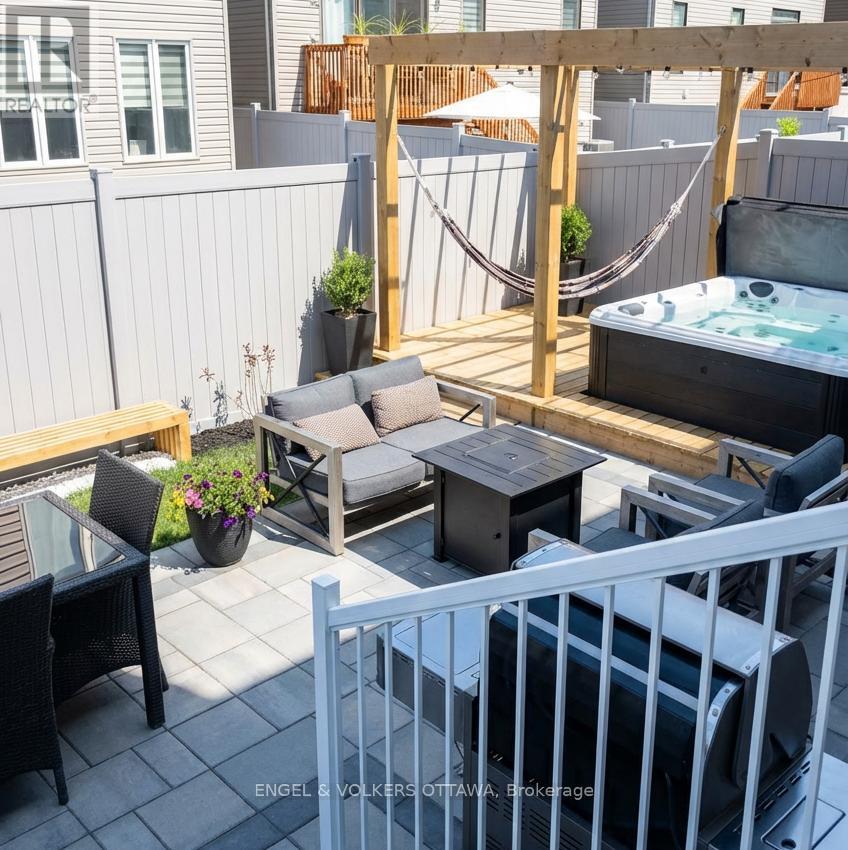 A patio with a hot tub and a hammock.