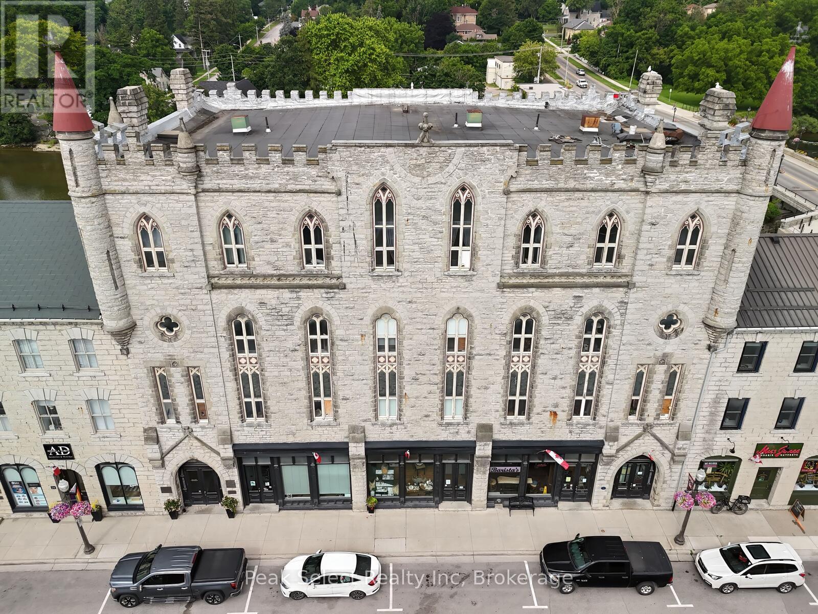A castle-like building with a parking lot in front.