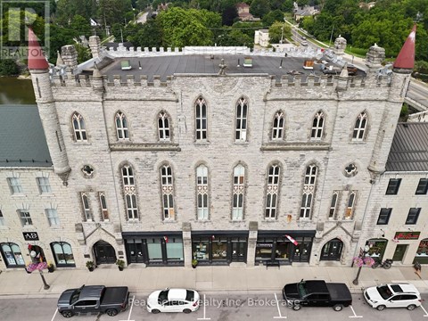 A castle-like building with a parking lot in front.