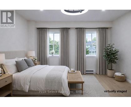 A bedroom with a large bed and a window with curtains.