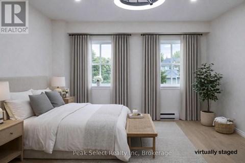 A bedroom with a large bed and a window with curtains.