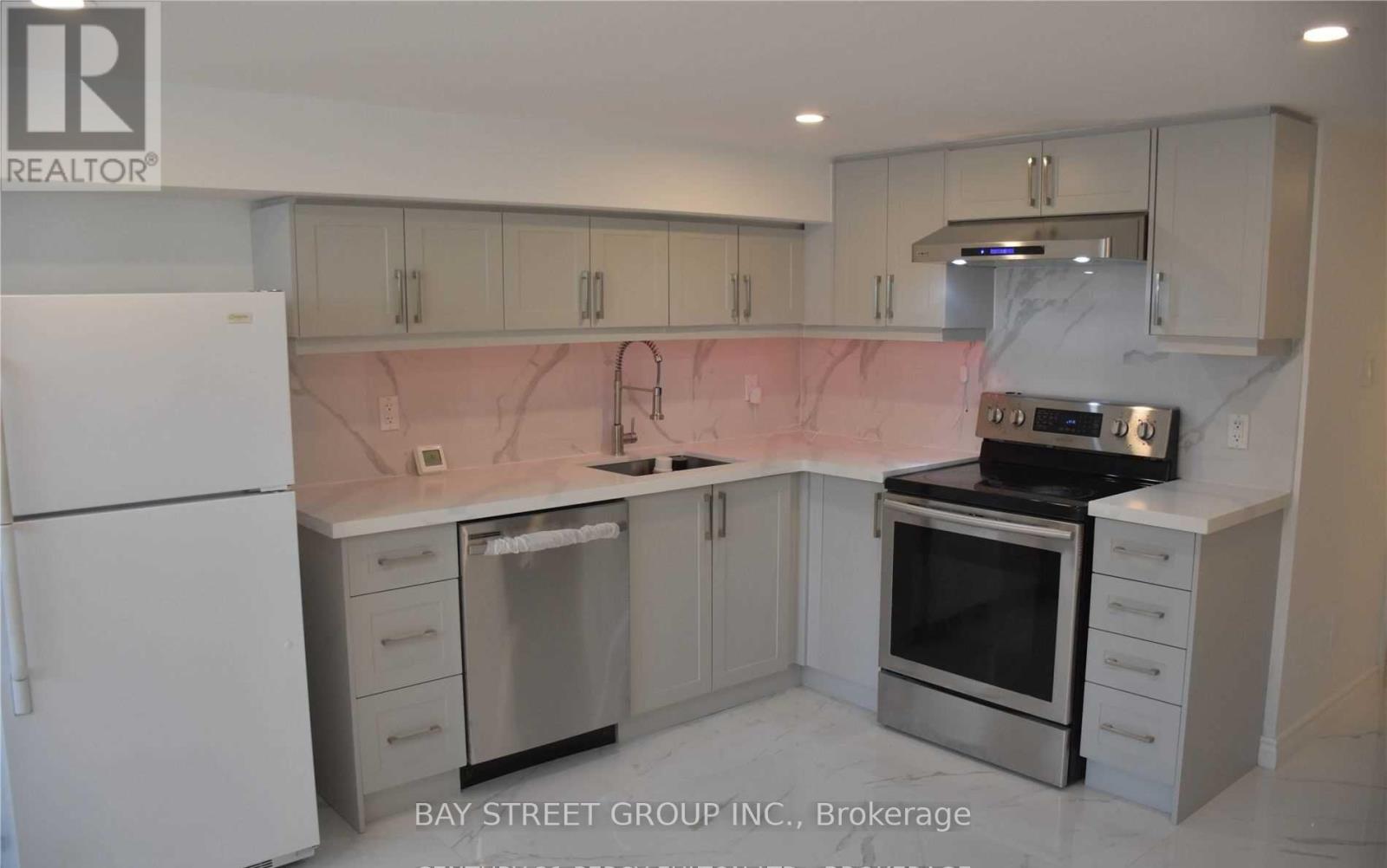 A kitchen with a refrigerator, oven, and microwave.
