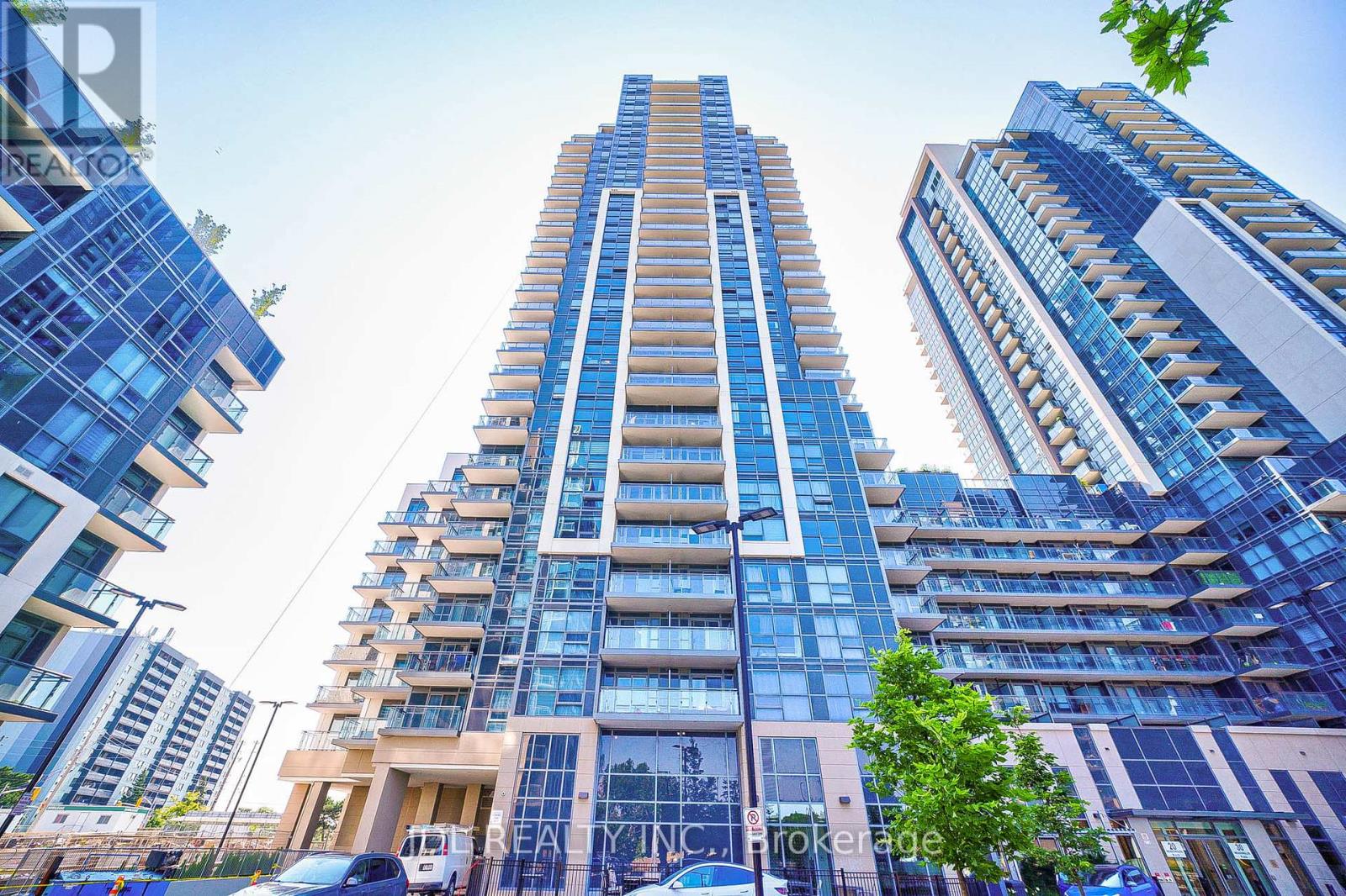 A tall blue and white building stands in front of other buildings.