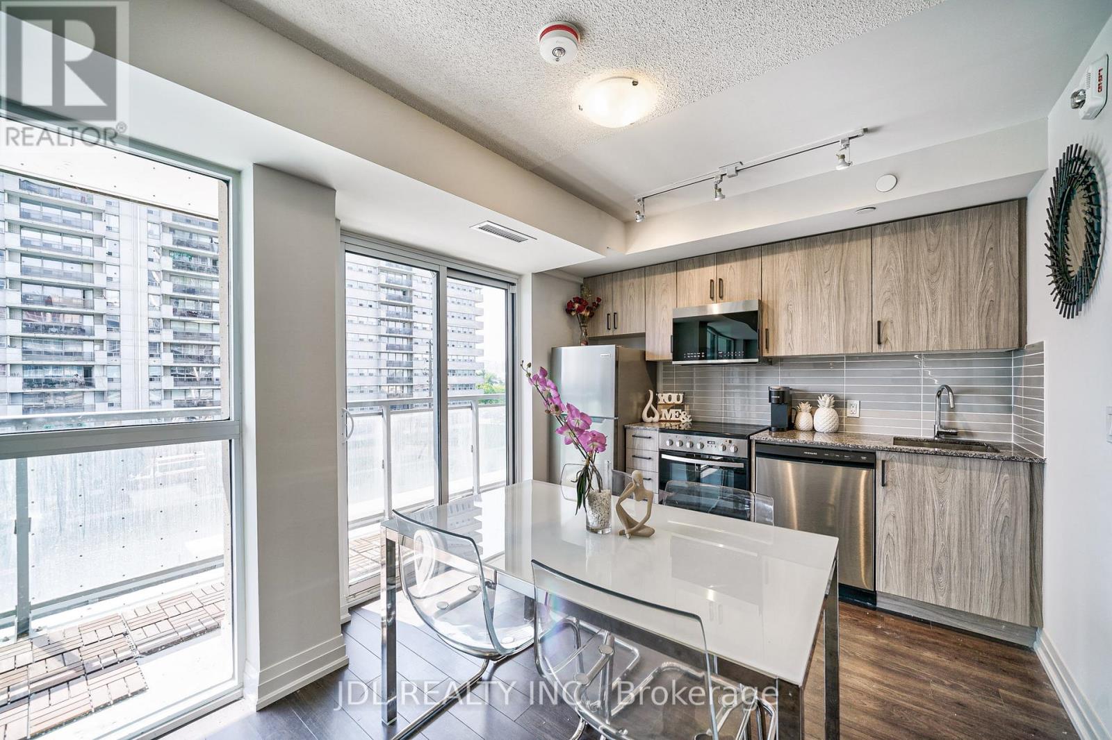 A modern kitchen with a glass table and stainless steel appliances.