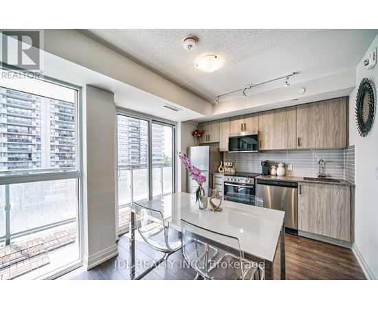 A modern kitchen with a glass table and stainless steel appliances.