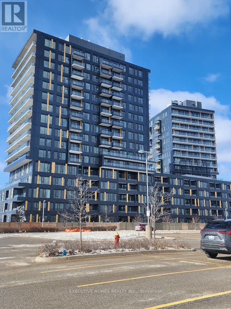 A modern apartment building with a parking lot in front.