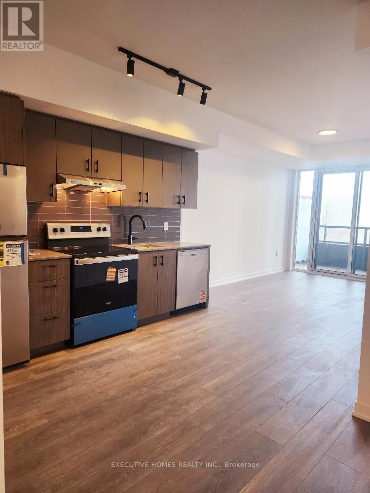 A kitchen with wooden floors and a white wall.