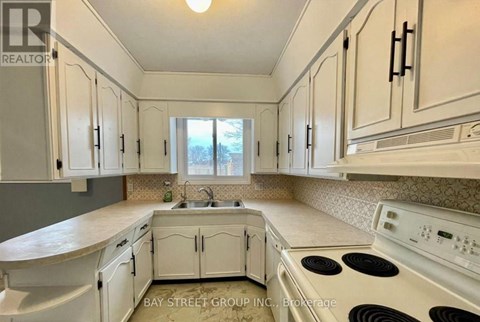 A kitchen with white cabinets and appliances.
