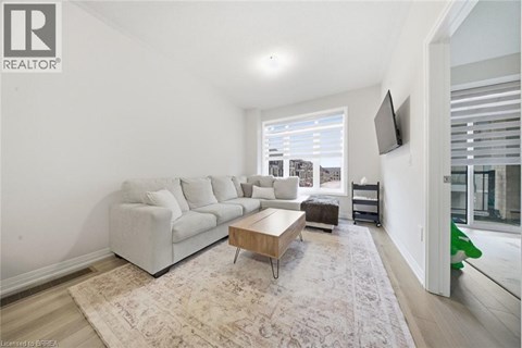 A living room with a white couch and a rug.