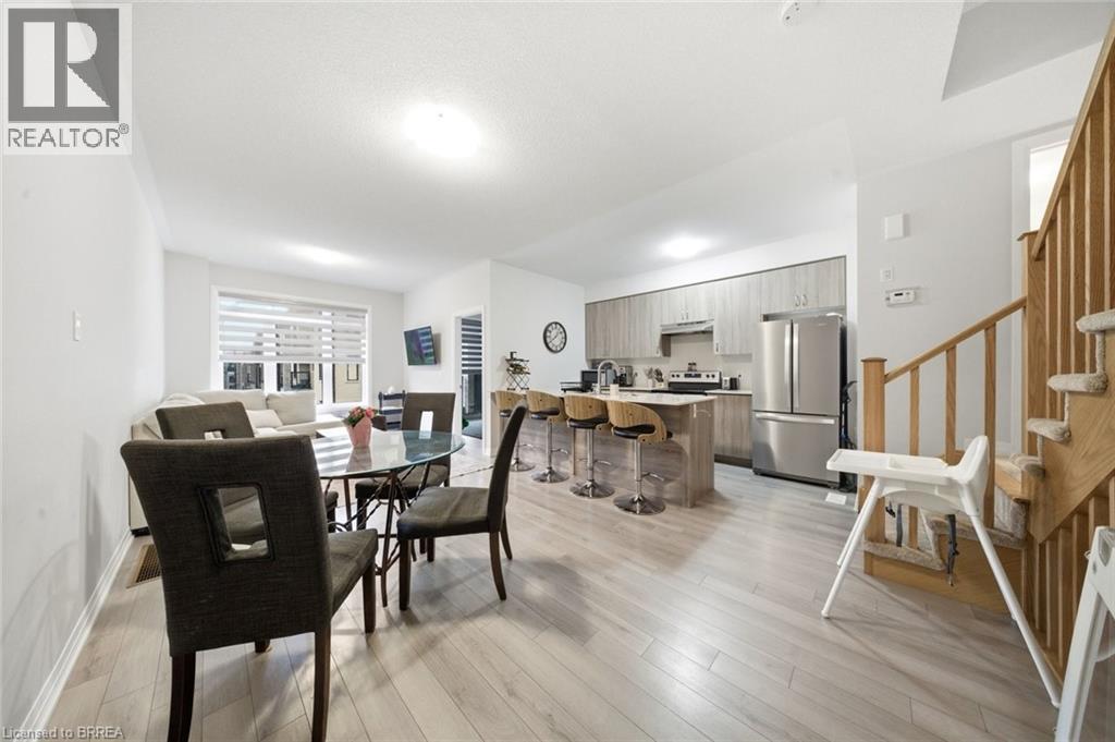 A well-lit open plan living and kitchen area with a dining table and chairs.
