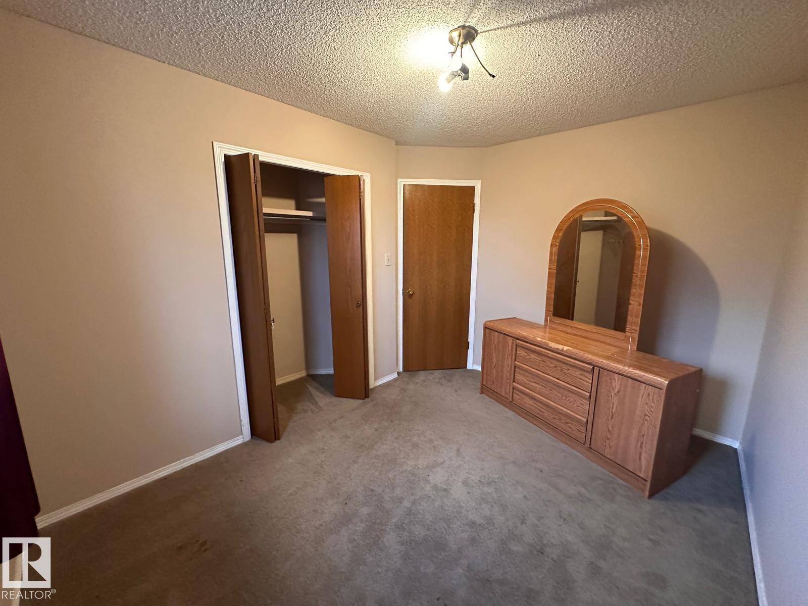 A bedroom with a dresser and mirror.