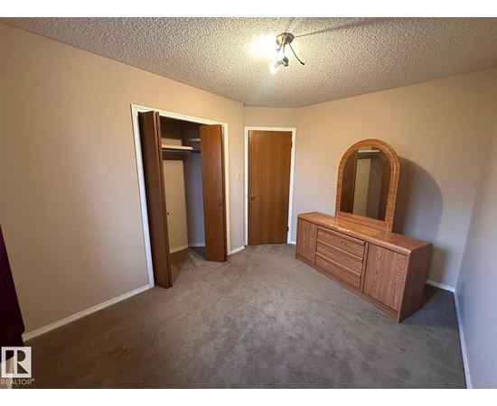 A bedroom with a dresser and mirror.