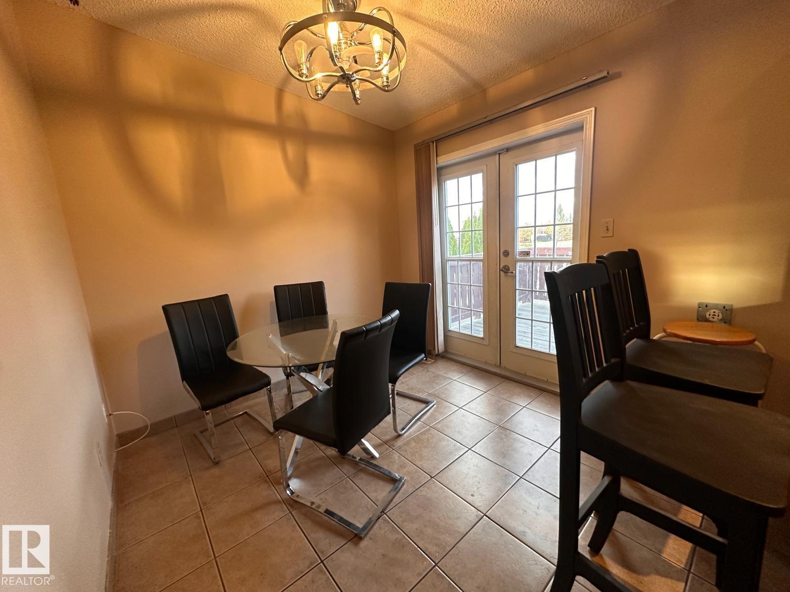 A dining room with a table and chairs.