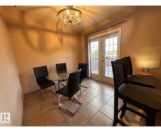 A dining room with a table and chairs.