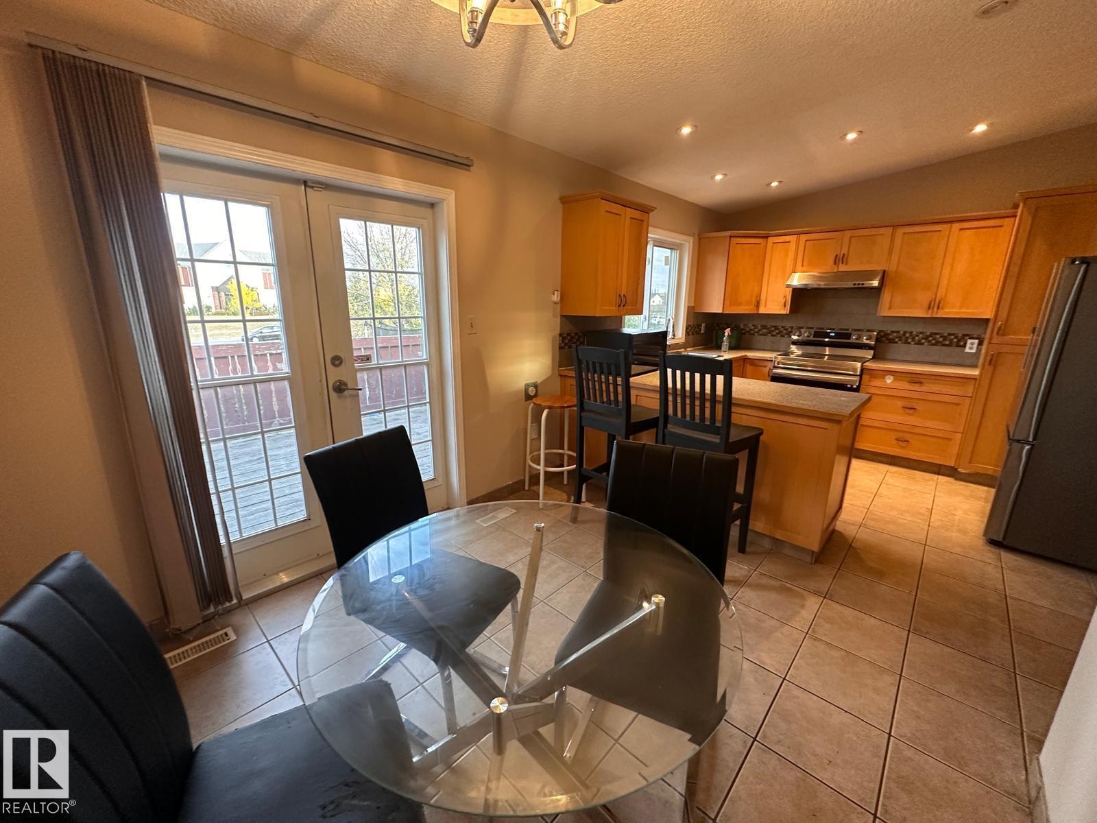 A kitchen with a glass table and chairs in the middle of the room.