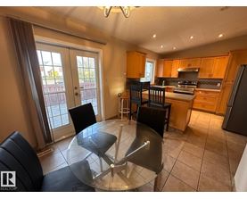 A kitchen with a glass table and chairs in the middle of the room.