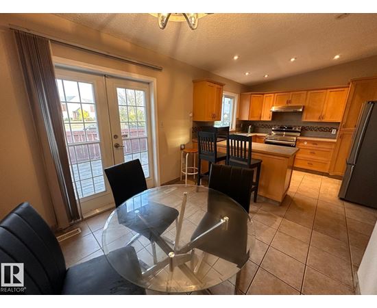 A kitchen with a glass table and chairs in the middle of the room.