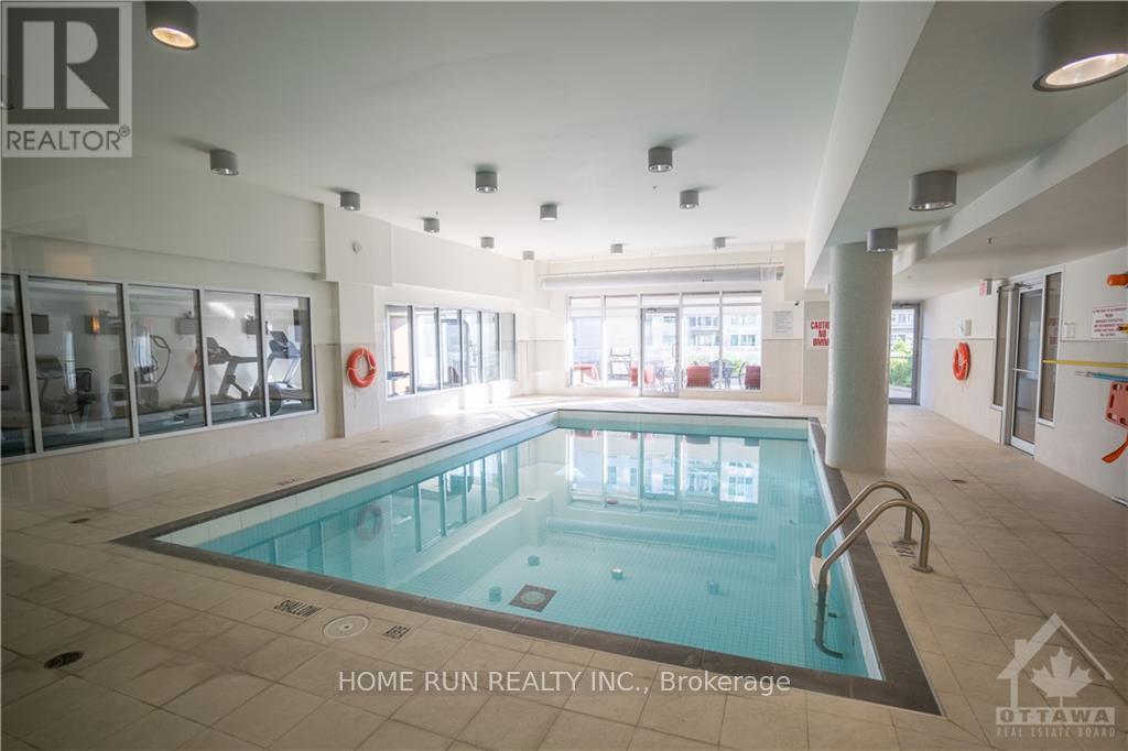 A swimming pool inside a building with Home Run Realty Inc. logo on the wall.