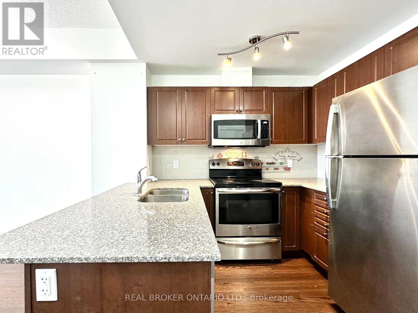 A kitchen with a granite countertop and stainless steel appliances.