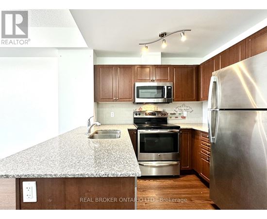 A kitchen with a granite countertop and stainless steel appliances.