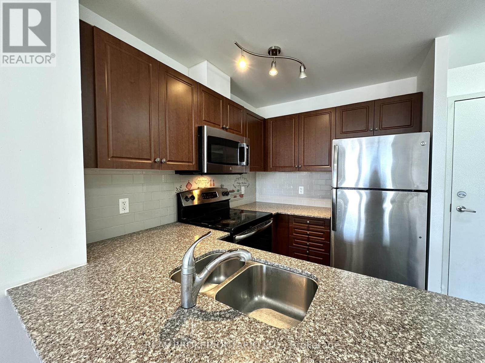 A kitchen with a granite counter top and stainless steel appliances.