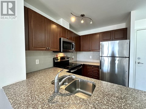 A kitchen with a granite counter top and stainless steel appliances.