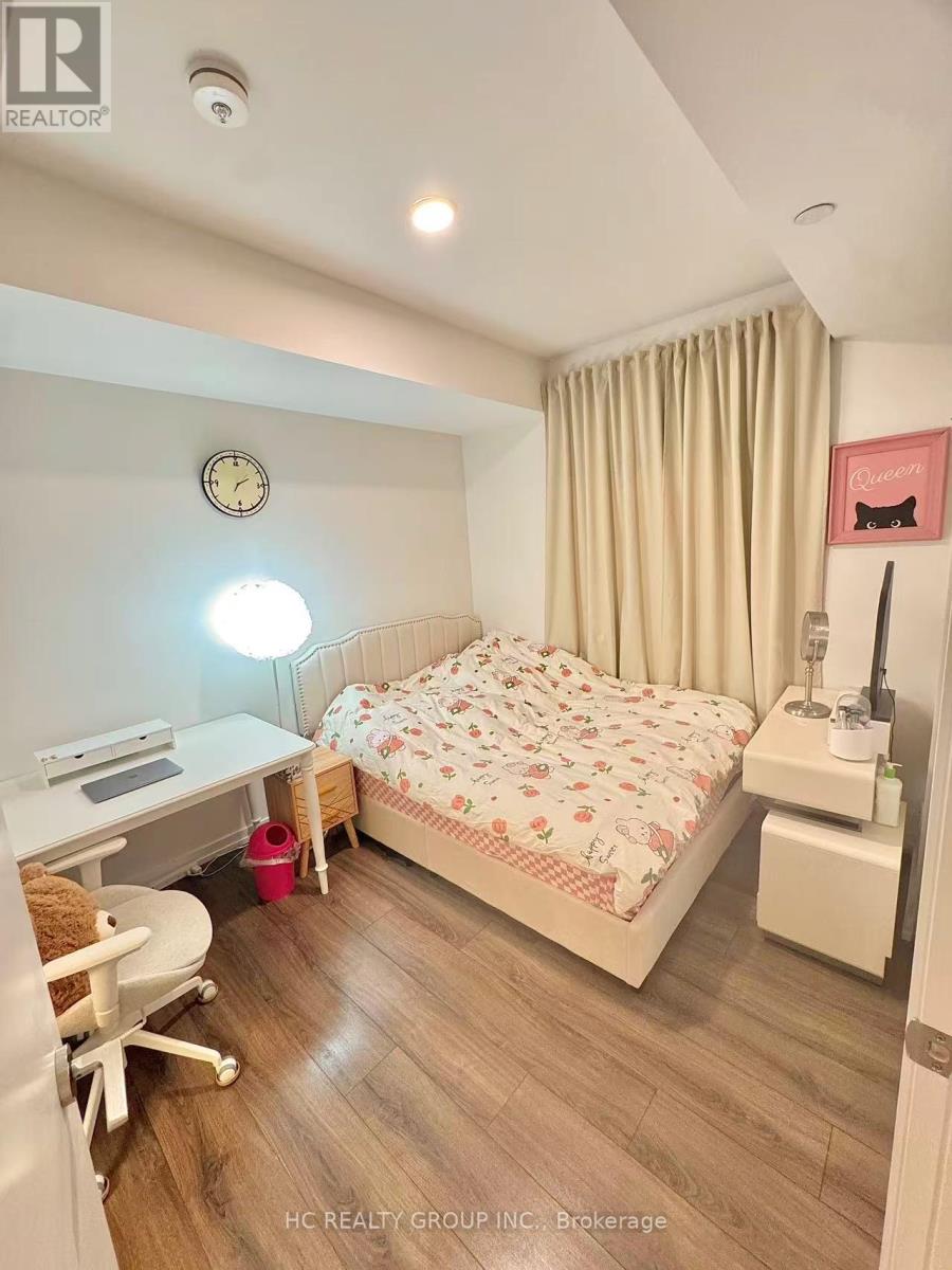 A bedroom with a bed, desk, and chair.